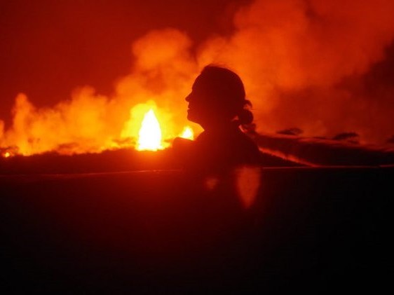 Einat Lev stands in front of a Kilauea lava fountain. Credit: Brett Carr