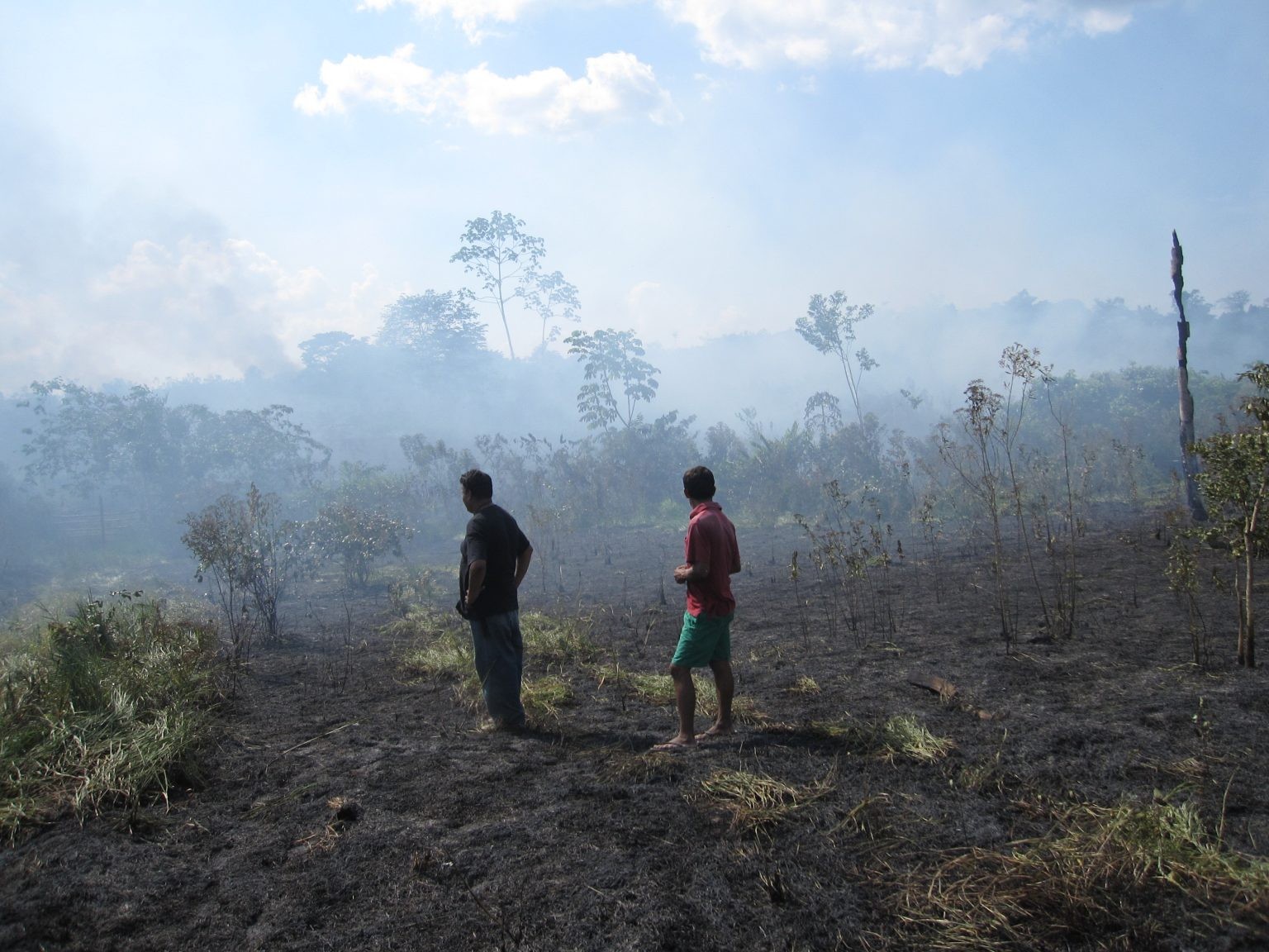 Farmers in a still-smoking landscape where a cooking fire escaped into surrounding scrubland near Pucallpa, in the Peruvian Amazon. Credit: Kevin Krajick