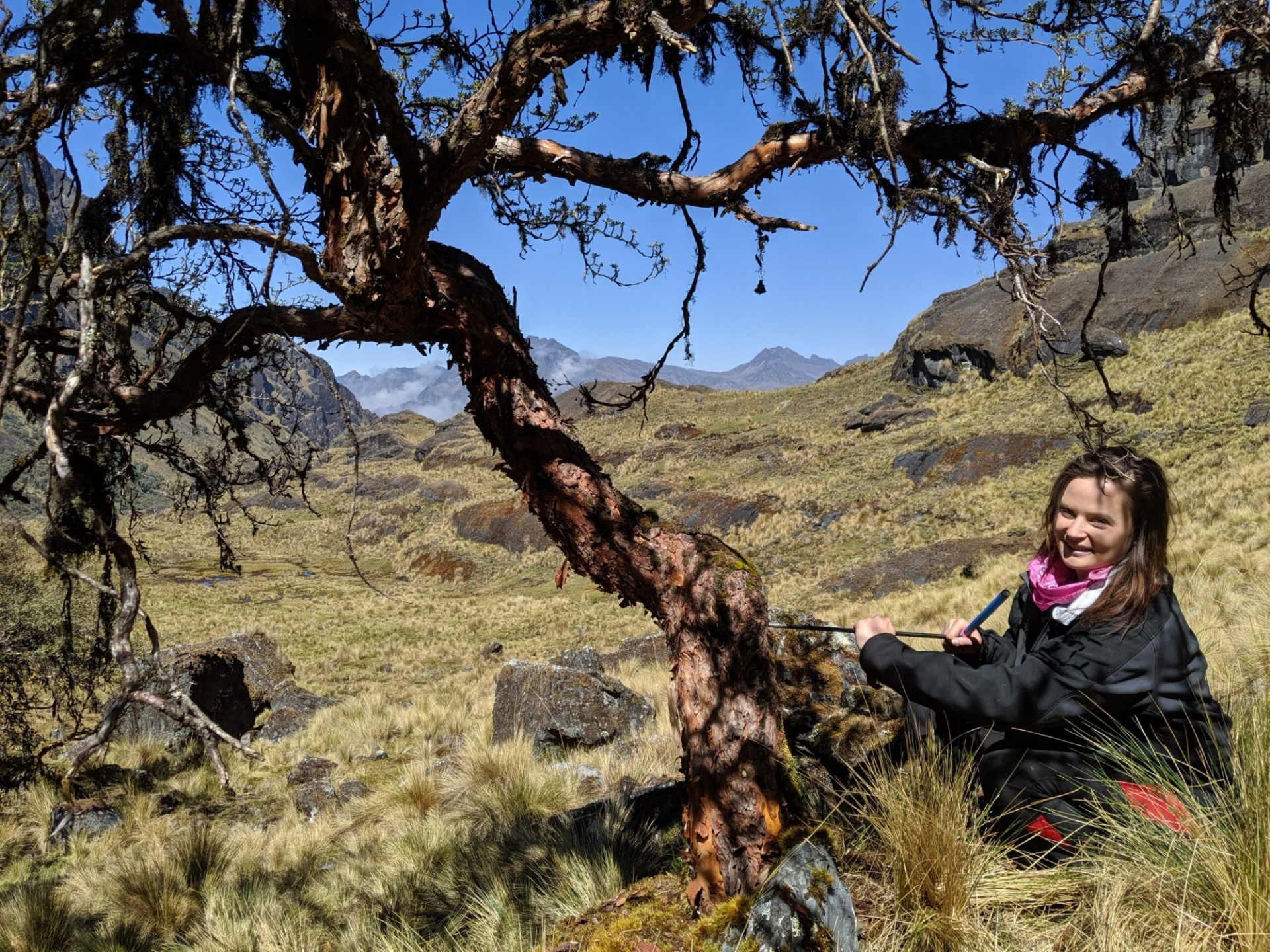 Rose Oelkers kneels by a tree in Bolivia.