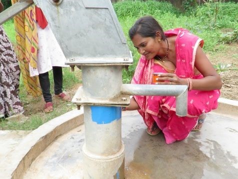 A social work student coloring the handpump blue to denote that the pump has safe limits of fluoride. Credot: Pooja Iyengar