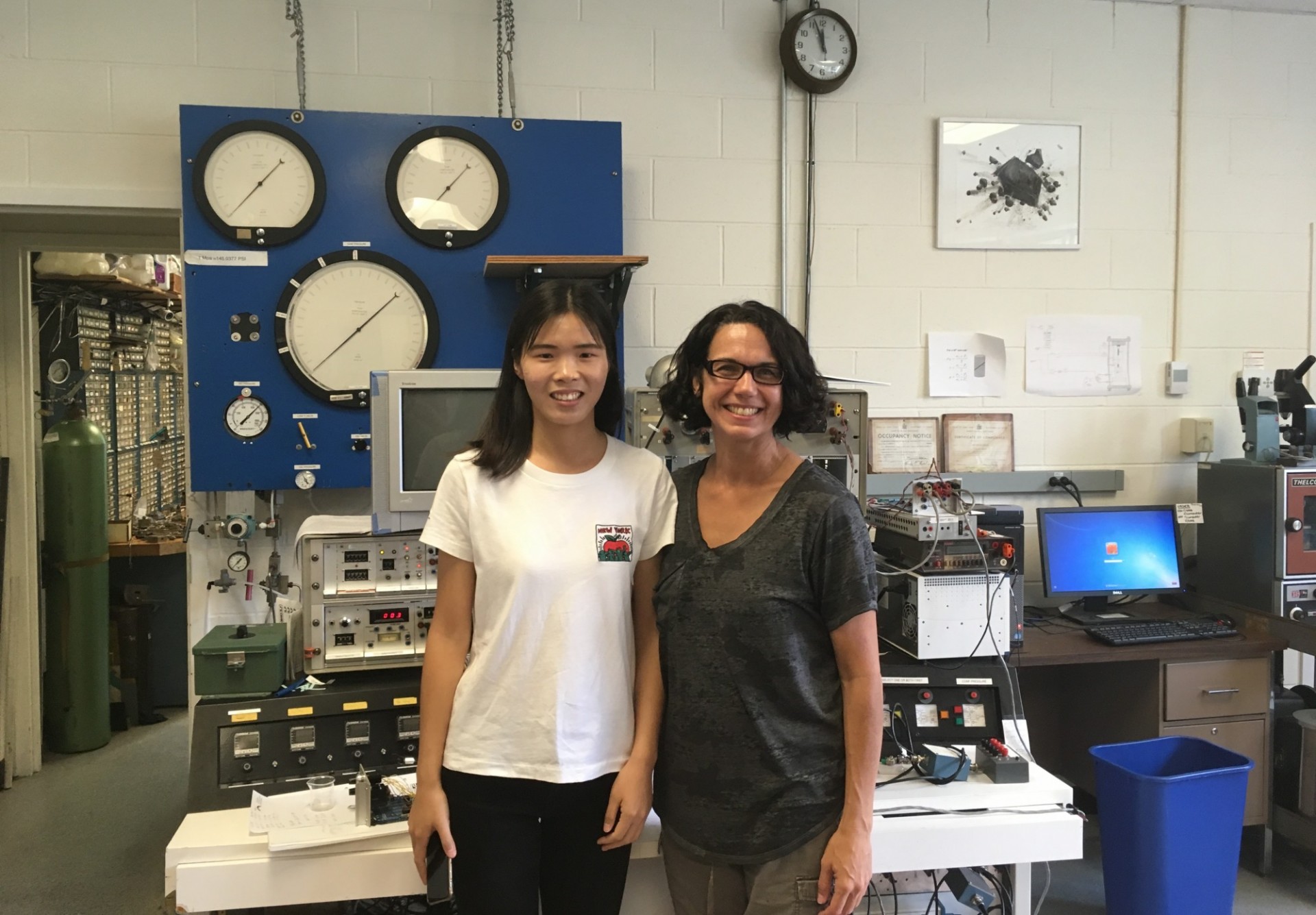 Visiting researcher Daning Zhong and Christine McCarthy pose in front of the triax control panel (2018).