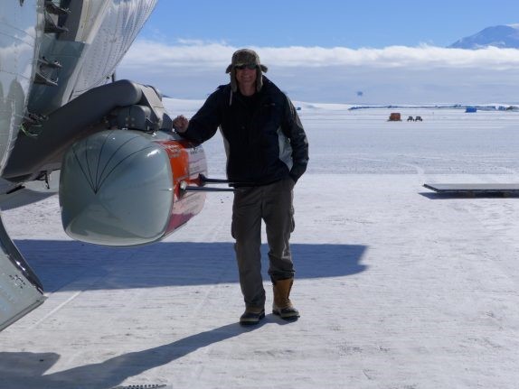 Frearson standing next to the IcePod after installing it onto a military LC-130 Hercules plane in Antarctica. Credit: Winnie Chu