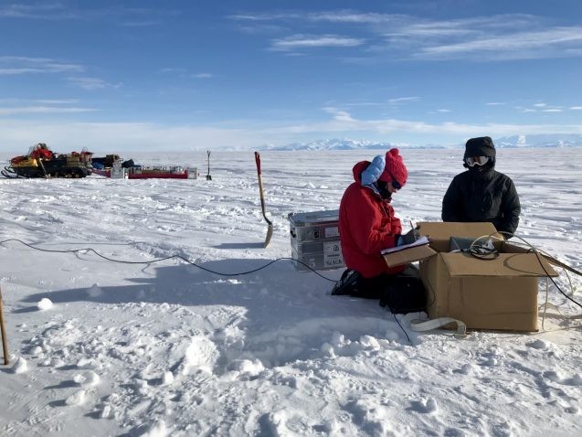 Lead author Chloe Gustafson and mountaineer Meghan Seifert install geophysical instruments to measure groundwater below West Antarctica’s Whillans Ice Stream. Credit: Kerry Key