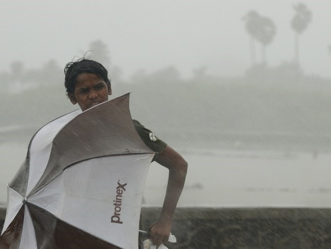 An Indian youth walks during heavy rain showers in Mumbai on June 18, 2013. The monsoon covers the subcontinent from June to September. Credit: Diariocritico de Venezuela 