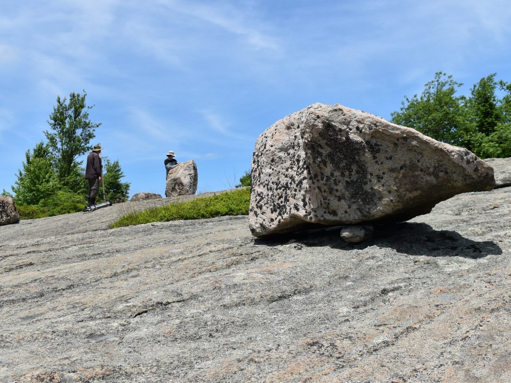 Precariously balanced boulders near New York City dropped by glaciers at the end of the last ice age may hold clues to the maximum size of earthquakes the region could suffer. Here, researchers at Black Rock Mountain, north of the city. Credit: Kevin Krajick/Earth Institute