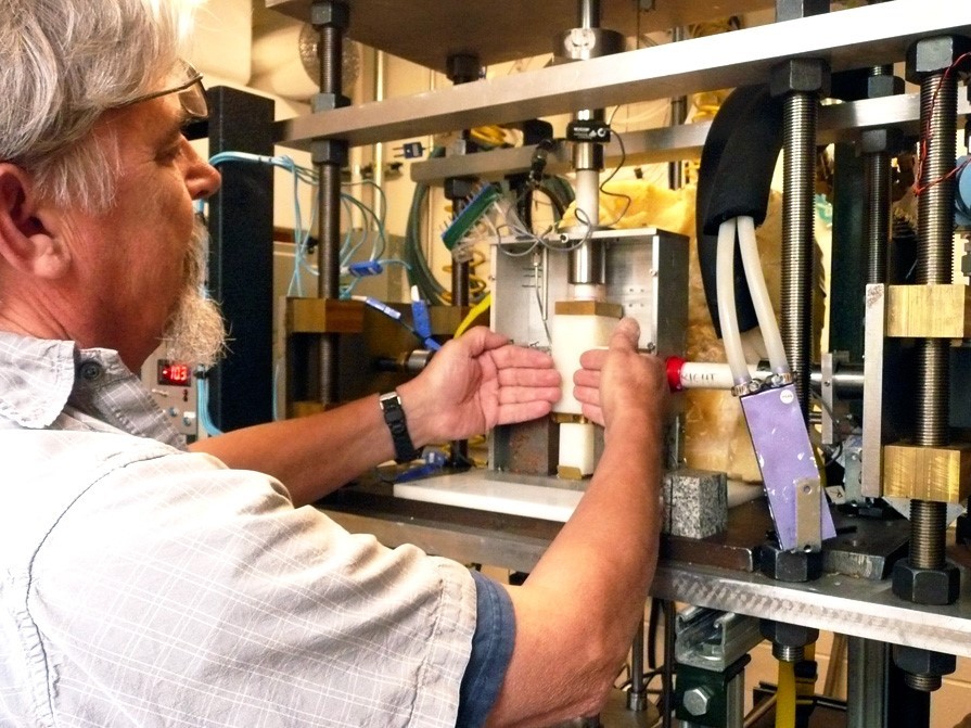 Research engineer Ted Koczynski explains how rock surfaces put pressure on a block of ice from each side as the ice is pushed downward in the new cryogenic deformation apparatus. Depending on the configuration, sensors throughout the device can measure friction, viscosity and anelasticity. Credit: Lamont-Doherty Earth Observatory.
