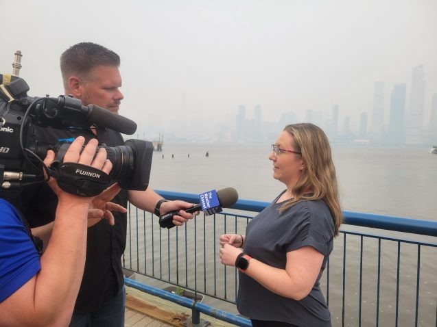 Róisín Commane, an atmospheric chemist at Columbia Climate School’s Lamont-Doherty Earth Observatory, speaks with a Weather Channel reporter in front of a smoke-choked New York City skyline.