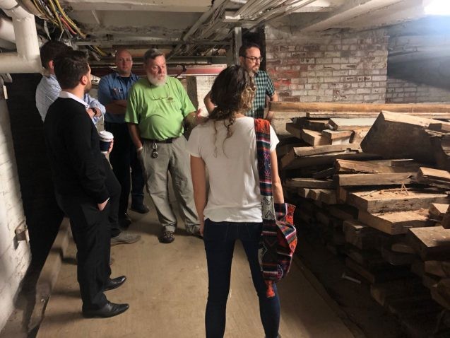 In the Terminal Warehouse basement, tree-ring scientists and building staff inspect original joists that were removed from a section of the building during a renovation. Some had more than 150 visible annual rings. Credit: Mukund Palat Rao