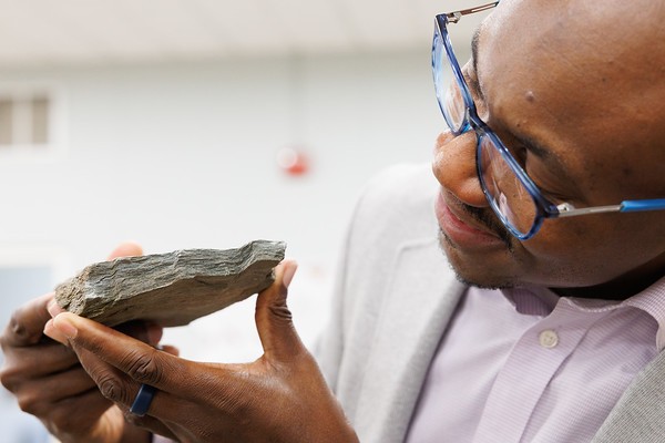 Credit: Sirin Samman Photography Scientist looking at a rock sample