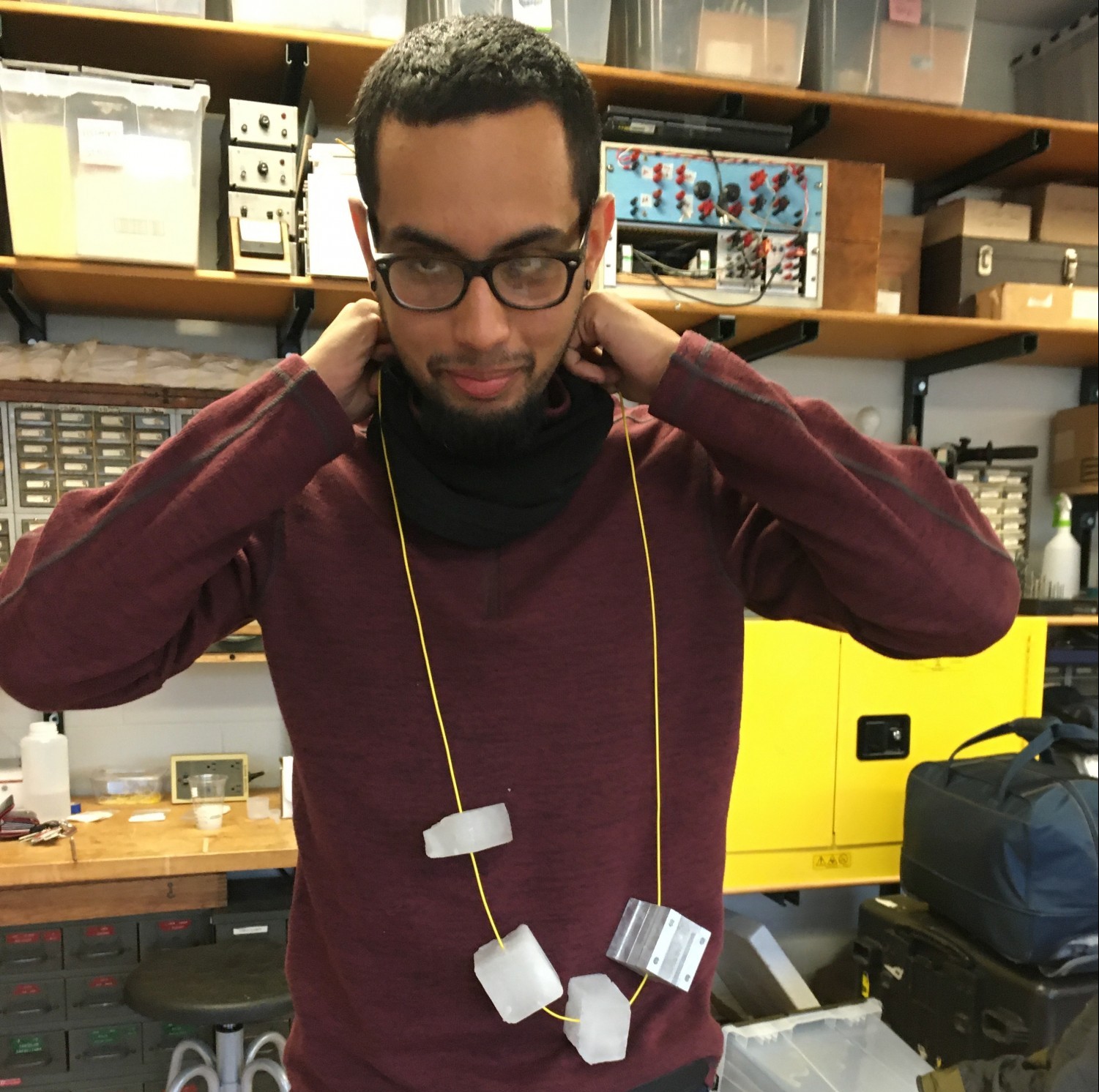 Vishaal Singh demonstrates a "necklace" of fiber optic cable and ice pieces, an early iteration on sample prep for tether testing (2019).