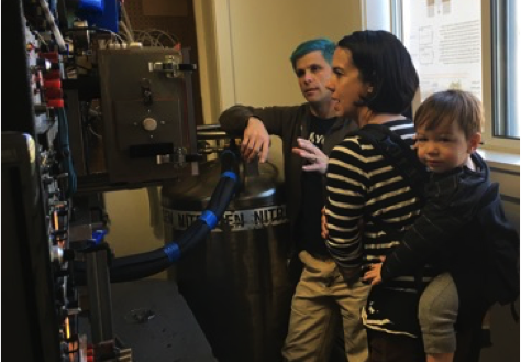 Sporting blue hair, Mike Nielson discusses the LN-cooled cryostat with Christine McCarthy (while eternally sick from daycare Seb hangs on).