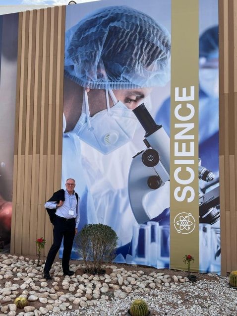 alex halliday standing in front of 'science' banner