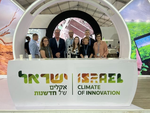 people stand behind a sign that says "israel climate of innovation"