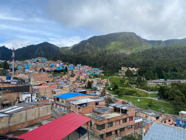 dense urban development against a green space and mountainous backdrop