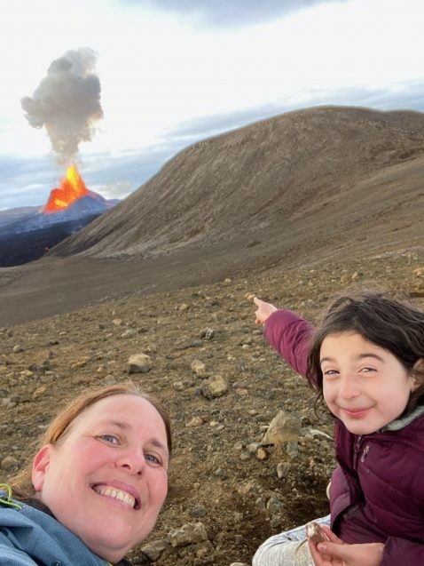 einat lev and daughter point at erupting volcano