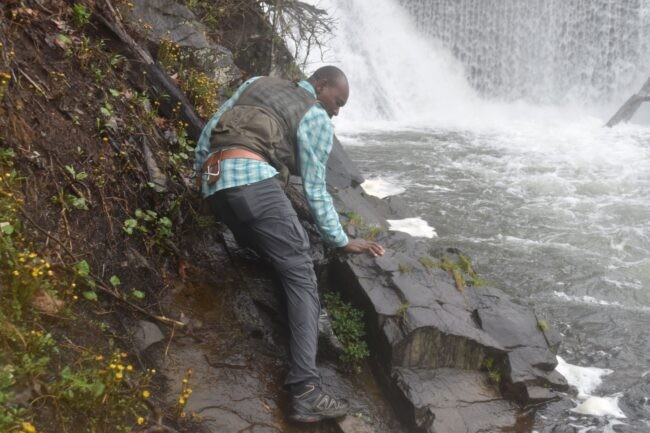 Man on rock near waterfall