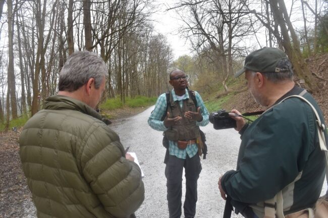 Man talking to two journalists.