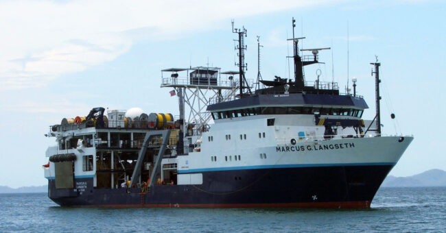 A photo of the R/V Langseth at sea, showing the bow and bridge, and the aft where the streamers are located.