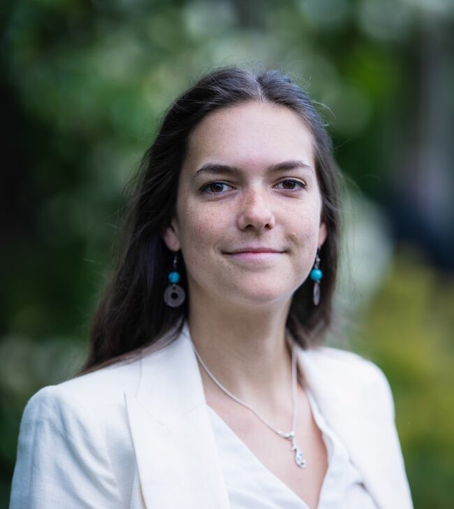 Headshot of woman with greenery in background