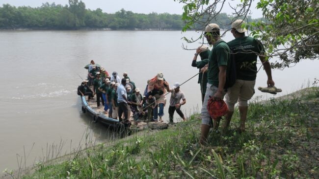 Small boat with group of people being pulled to land