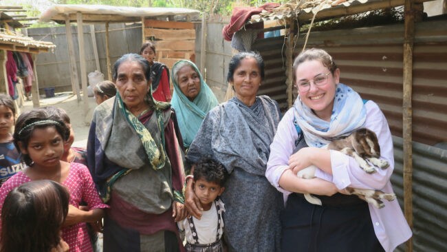 Women and children in Bangladesh, one holding a goat