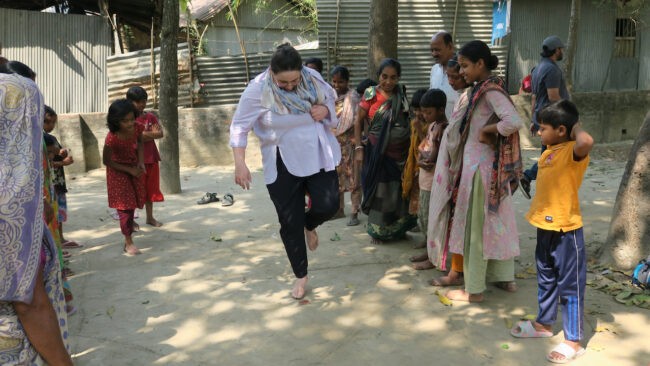 Woman and children playing hopscotch-like game