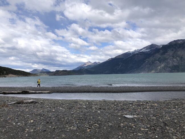 Graduate student Lauren Lewright walking across a pebble beach in Patagonia (March 2024). Credit: Jacky Austermann, Lamont-Doherty Earth Observatory
