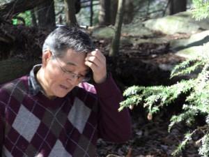 Seismologist Won-Young Kim considers his next step for the installation of a seismometer in the woods behind the Kent School's St. Joseph's Chapel.