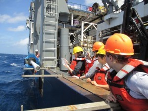 A sediment core is secured along the ship’s rail for sampling.