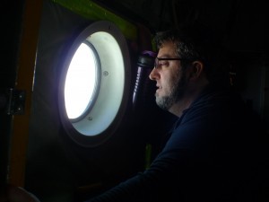 Chris Zappa,oceanographer and project optics expert, peers out the window of the LC130 aircraft. 