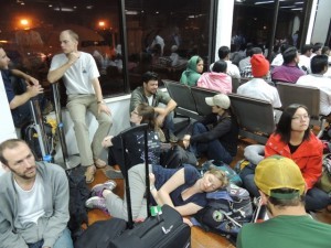 I very tired group of travelers waiting a Dhaka airport early in the morning.