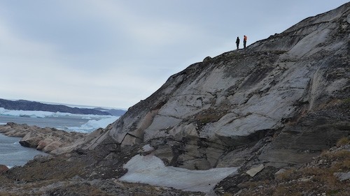 Gabriel and Magnus climb to a high point to get a better view of the dense ice pack in front of Alison fjord. (Photo M. Turrin)