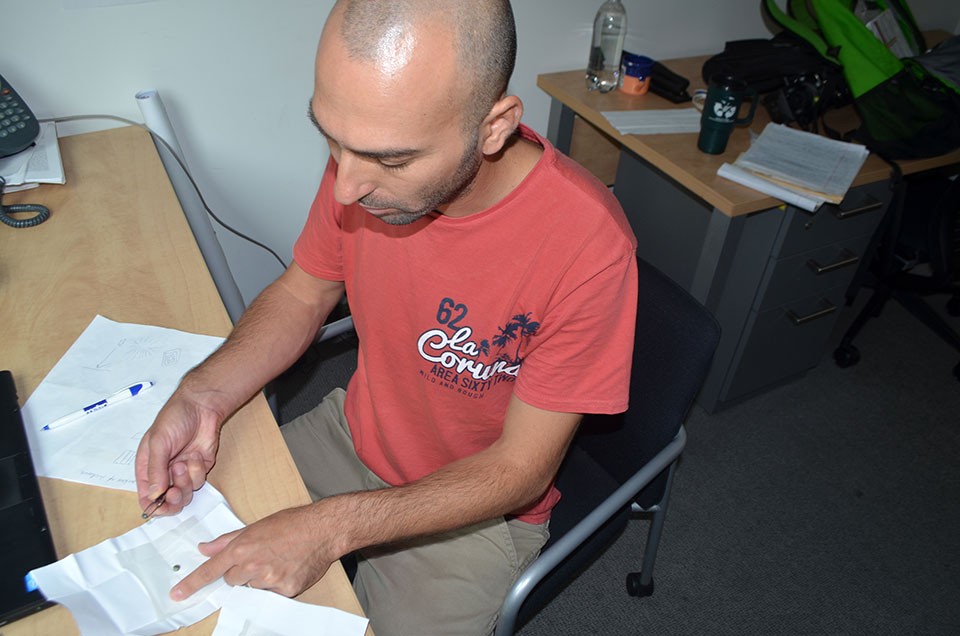 Yaakov Weiss, a geochemist at Lamont-Doherty Earth Observatory, is looking for rare diamond samples from Arkansas and Colorado in order to compare with those from the far north. In his office, he inspects industrial-grade diamonds. (Kevin Krajick) 2