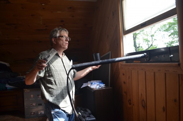 Geochemist James Ross of Lamont-Doherty Earth Observatory installs an air-quality monitor in a home neighboring a hydraulic-fracturing drill pad. CLICK FOR A SLIDESHOW