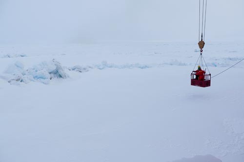 The 'man-basket' lowering Tim Kenna and crew member to the ice via crane to do sampling from a pressure ridge. (photo Bill Schmoker)