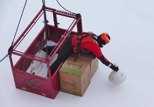 Ship crew is deployed to position the boxes of small 'seaworthy vessels' and the tracking buoy onto the ice. (Photo Bill Schmoker) 