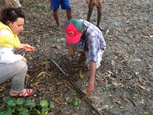 Céline and Basu examine a core of samples brought up by the auger gouge.