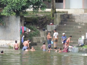 A group of children play in a pond while we try to figure out where to find land dry enough to work in.