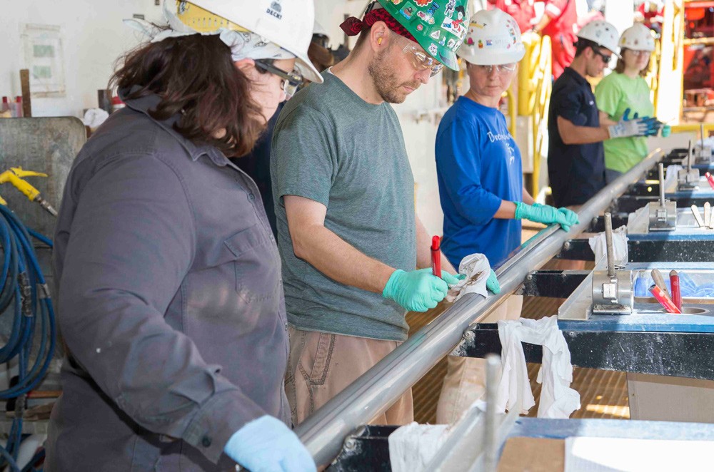 The team aboard the JOIDES Resolution collected the first four cores of Expedition 361 from the Natal Valley site. Here, scientists prepare to open the first. (Tim Fulton/IODP) scientists-with-first-core-tim-fulton