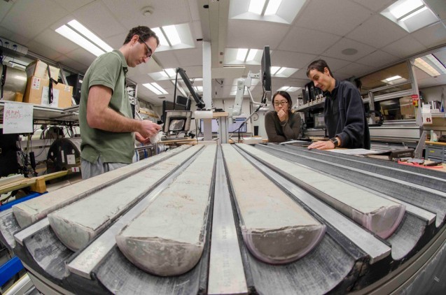 Sedimentologists Andreas Koutsodendris of the University of Heidelberg, Masako Yamane of the Japan Agency for Marine-Earth Science and Technology, and Thibaut Caley of the University of Bordeaux study freshly split cores. Photo: Tim Fulton, IODP