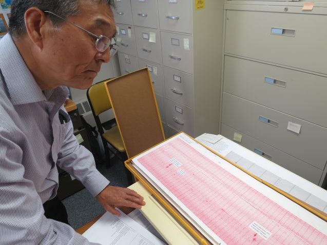 Seismologist Won-Young Kim pulls out the original paper seismogram showing the jet impacts, and subsequent collapses, of the World Trade Center towers. "It was a very painful day," he said. (Kevin Krajick)