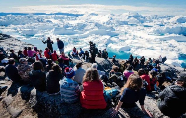Participants in Students on Ice listen to scientist Maureen Raymo (top left) discuss climate change at the foot of Greenland’s Illissaat Icefjord. (Image: Martin Lipman/Students on Ice)