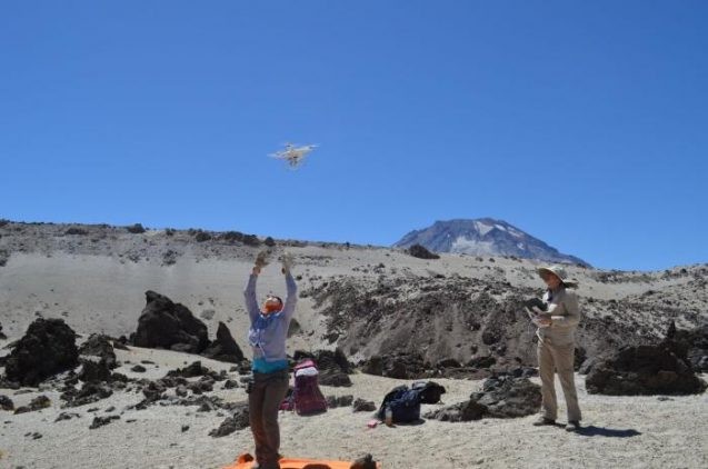 Elise Rumpf launches a small drone with a camera over Chile’s Quizapu volcano. Photo: Kevin Krajick