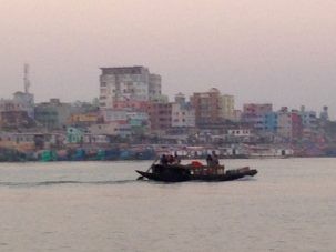 A set of colorful houses line the bank of the broad Meghna River. We continue south to find sampling sites.