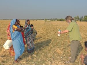 Chris measuring the reflectance spectra of the ground while some local woman look on.