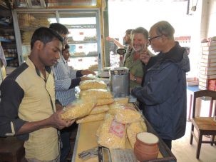 Chris smiling broadly as he and Humayun buy 11 lbs of Jordibaja, a local Kushtia snack food from the most famous bakery that makes it.