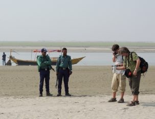 Our police escort watches Chris and Dan measuring spectra on a char (sandy river island) to compare with satellite measurements.