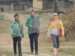 Liz in Rajshahi walking back to our group protected by two policewoman that were part of our escort during a quick visit back to our van.
