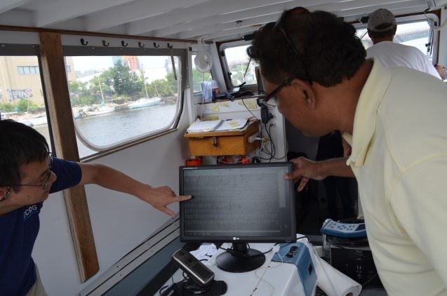 Lamont-Doherty geochemist Beizhan Yan (left) and Goes inspect images of tiny debris generated in real time by an experimental apparatus.