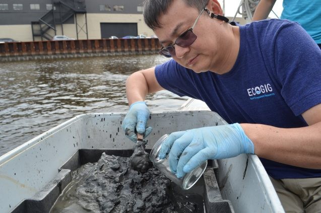 Yan samples the muck. It will go back to the lab for analysis.